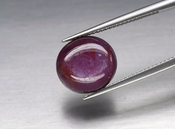 8.45ct 12.2x11.3mm Oval Cabochon Reddish Purple Sapphire Unheated Guinea